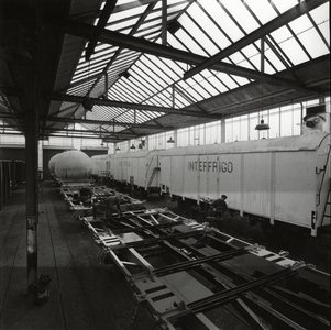 168557 Interieur van de wagenwerkplaats van de N.S. te Amersfoort, met enkele koelwagens van Interfrigo en enkele silowagens.